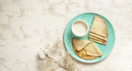 The top view on pancakes with holes. Made of yeast dough. Decorated with sour cream. Top view. Flat...
