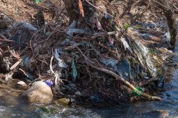 Plastic and foam garbage floating on the surface of the river