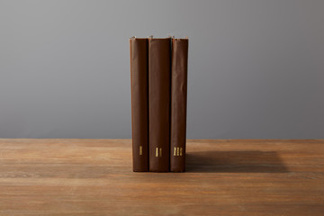Brown books on textured wooden surface isolated on grey