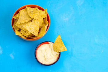 mexican corn chips nachos with sauce on blue background top view copy space