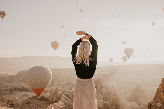 Bright woman on the background of balloons in Cappadocia in Turkey at sunrise