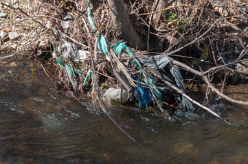 Plastic and foam garbage floating on the surface of the river