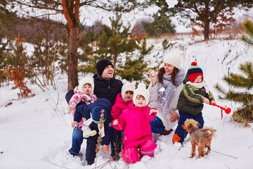 Fototapeta na wymiar Parents and their children play in the snow and laugh loudly