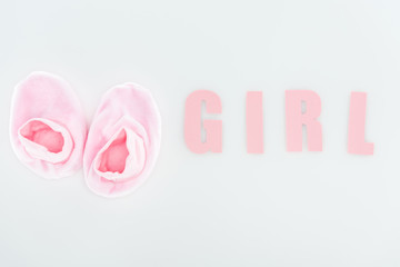 top view of pink booties and girl lettering isolated on white with copy space