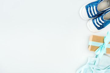 top view of blue sneakers, gift box and bonnet on white background with copy space