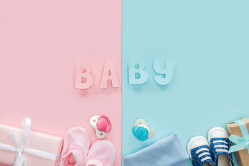 top view of pacifiers, gifts, hat, booties, sneakers and baby lettering