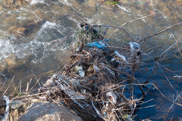 Plastic and foam garbage floating on the surface of the river