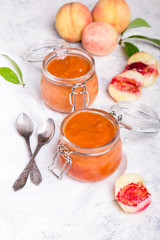Homemade peach jam with organic fruit. Sweet preserves on a light background