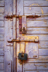 Old lilac color wooden plank door with padlock