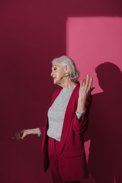 Cropped photo of elderly lady wearing stylish suit on red background
