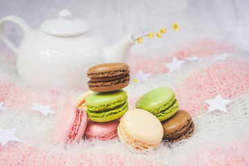 Delicious macarons with a tea in a teapot