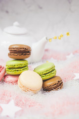 Delicious macarons with a tea in a teapot