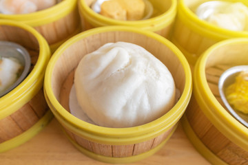 close up of steamed pork bun in bamboo basket