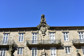 Fototapeta na wymiar Building with Atlas sculpture, coat of arms and iron railings. Pazo de Bendaña. Plaza del Toural, Santiago de Compostela, Spain.