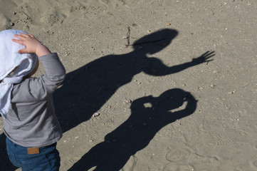 child and shadow on the beach