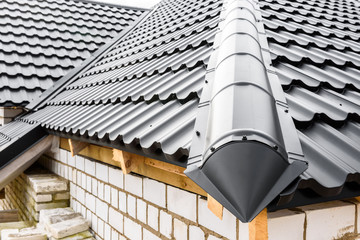 Construction of the roof of the house. Metal tiles.