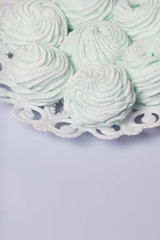Homemade marshmallows laid on a plate. Marshmallow with mint, with a green tint. On a white background.