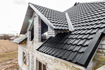 Construction of the roof of the house. Metal tiles.