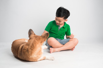 Obraz premium Cute little boy playing with dog at home