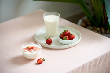 fresh organic yogurt with strawberries on table