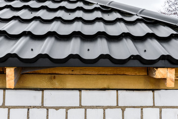 Construction of the roof of the house. Metal tiles.