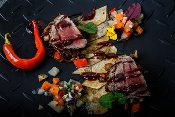 top view macro two pieces of medium raw grilled meat with red pepper