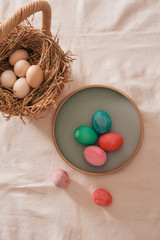 Easter eggs in the nest on rustic linen background