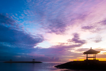 Pavilion Near Calm and Peaceful Beach on Sunrise with Two Other Pavilion Further To The Sea on Background. Colorful and Cloudy Sky in Monring. Concept of Harmony, Inner Searching and Uniting with Natu