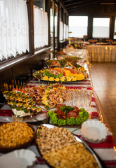 Buffet table of reception with cold snacks, meat and salads