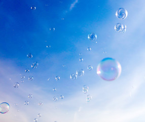 Soap bubbles fly in the blue sky