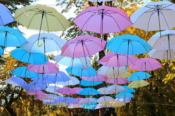 Fototapeta na wymiar Colored umbrellas hang in the air as a protective roof against rain and sunshine