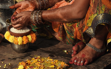 Hindu woman pray sun God, with food offerings, at dusk,in the bank of lake, during annual ritual...