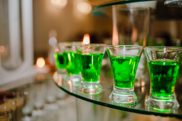 Obraz na płótnie Canvas Alcoholic drinks of green color in glass cups