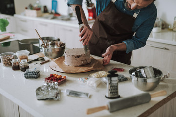 Kitchen table full of products and man making cake