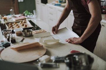 Obraz na płótnie Canvas Hands of man making carton box in the kitchen