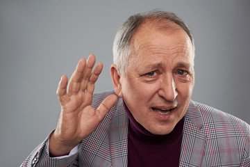 Man putting hand near the ear while listening attentively