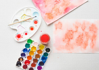 Palette with paintbrush and watercolors and paintings, top view, horizontal