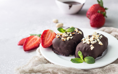 Glazed cheese curds with chocolate, peanut, strawberry and mint on a white plate. Sweet breakfast or dessert. High key.