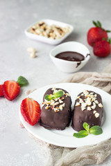 Glazed cheese curds with chocolate, peanut, strawberry and mint on a white plate. Sweet breakfast or dessert. High key.