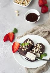 Glazed cheese curds with chocolate, peanut, strawberry and mint on a white plate. Sweet breakfast or dessert. High key.