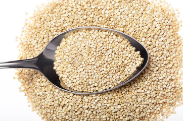 Raw organic superfood gluten free quinoa seeds in spoon closeup on white background