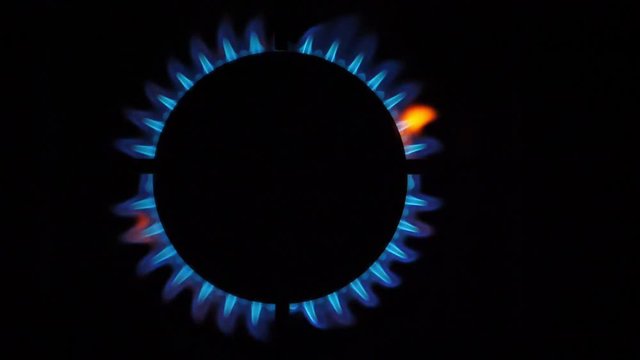 Kitchen burner flaming in the night, closeup. Top View
