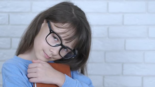 Schoolgirl nerd is hugging a book.