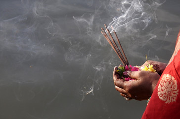  Hindu woman pray sun God, with food offerings, at dusk,in the bank of lake, during annual ritual Chhath Puja