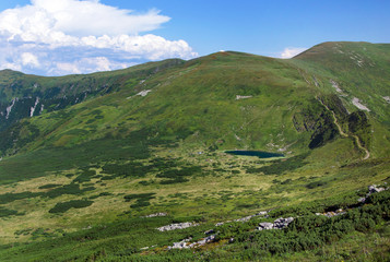 Fototapeta na wymiar Mountains with green vegetation and lake.