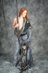 Fototapeta na wymiar Nude young woman with red hair and freckles with a chain in her hands in a vintage diving suit.