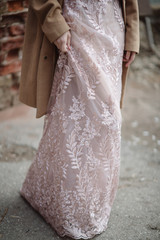 Young woman in a long pink dress with lace posing on the street