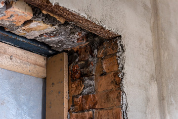 Part of brick doorway on plaster wall. 