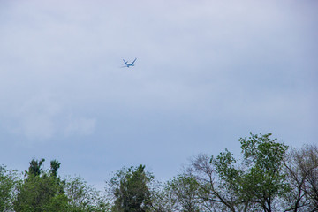 Distant airplane flying in the cloudy sky