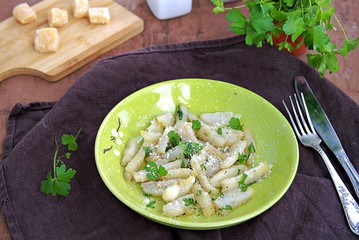 Roasted Jerusalem artichoke with cheese and parsley on a green plate. Healthy food